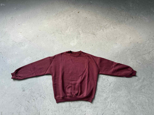 Maroon hoodie on a gray concrete surface